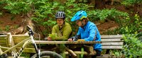 Zwei Radfahrer machen eine Pause und schauen auf eine Harz Karte