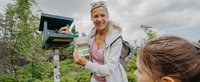 Frau und Kind stehen am Stempelkasten