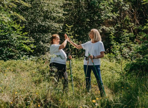 Zwei Nordic Walker freuen sich und klatschen ein