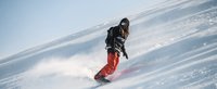 Snowboardfahrer fährt eine Piste hinunter