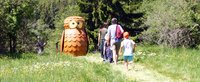Eine Familie neben einer Holzeule 