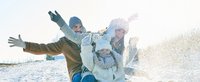Familie fährt Schlitten und freut sich 